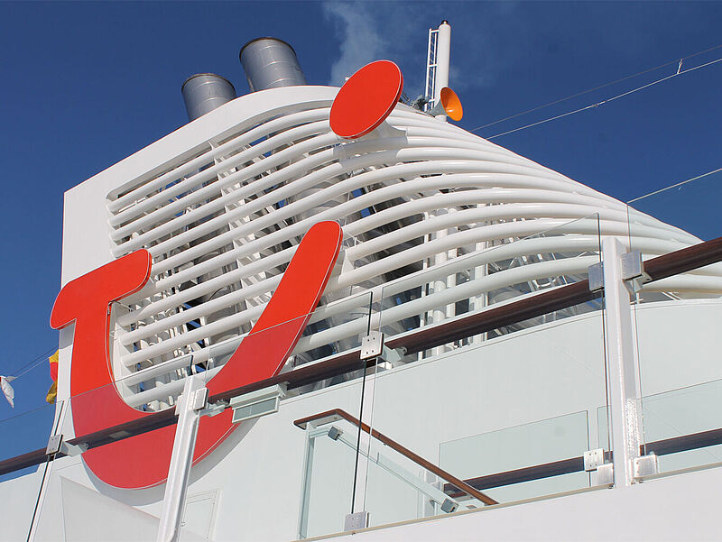 Die Mein-Schiff-Flotte wächst weiter. Foto: ck Schornstein eines Kreuzfahrtschiffes mit dem roten Smiley-Logo von TUI.