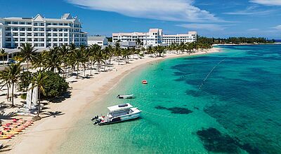 Das Riu Ocho Rios bei Ocho Rios an der Nordküste Jamaikas ist bereits geöffnet. Foto: Riu Luxuriöses Strandresort auf Jamaika, mit weißen Sandstränden, türkisblauem Meer, Palmen und Booten